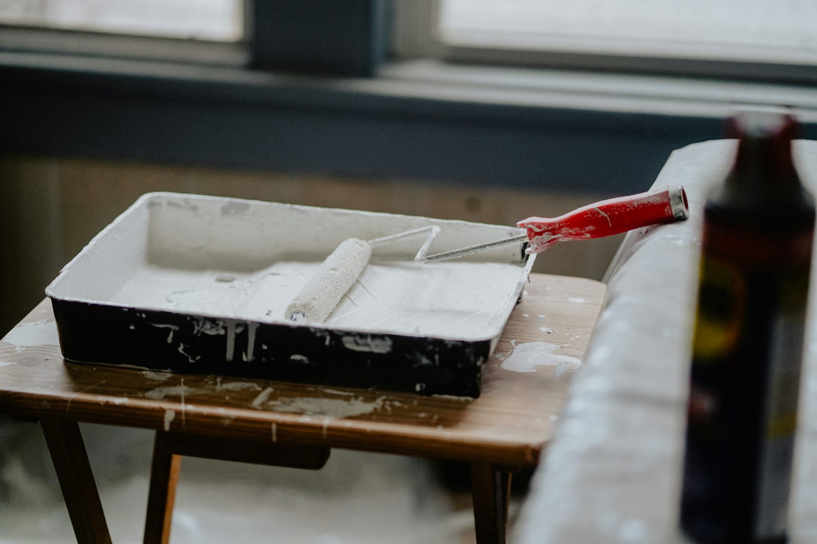 Verfbak met roller op een werktafel voor schilderwerk binnen
