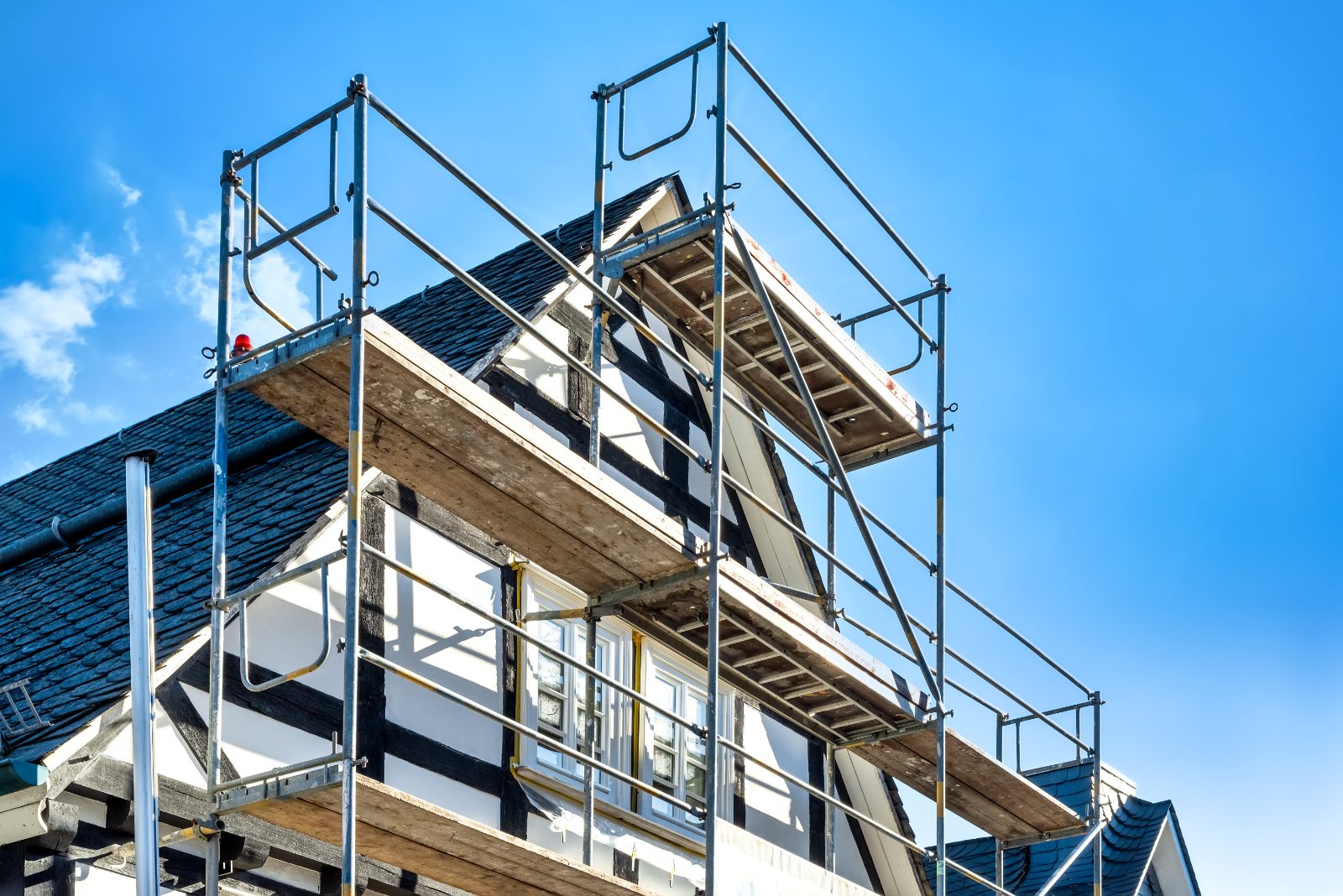 Steiger tegen een woning tijdens een renovatie van dak en gevel